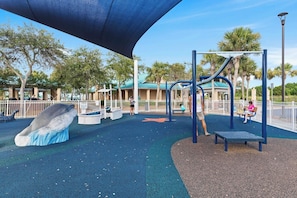 A playground with a slide, climbing structures, and a bench. - Venus 205 | Beach Service Included | Beach Getaway (Fort Walton Beach)