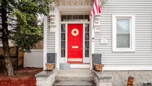 A house with a red door, stone steps, and a mailbox. - The Thomas Honeycomb Inn w/ Tiki Bar and Roof Deck (Salem)