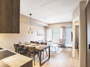 A modern kitchen with a dining area, a sofa, and a chair. - Äkäspokka by Interhome (Äkäslompolo)