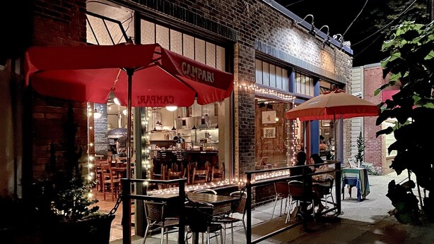 A restaurant with outdoor seating, red umbrellas, and a brick facade. - Cool apartment in vibrant Seattle neighborhood.Restaurants, bars and Light Rail. (Seattle)