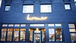 A building with a neon sign reading 'homer' above the entrance. - Cool apartment in vibrant Seattle neighborhood.Restaurants, bars and Light Rail. (Seattle)