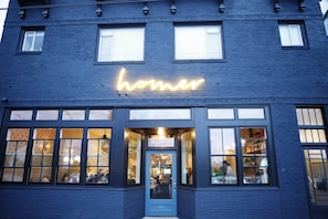 A building with a neon sign reading 'homer' above the entrance. - Cool apartment in vibrant Seattle neighborhood.Restaurants, bars and Light Rail. (Seattle)