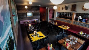 A restaurant with wooden walls, yellow tables, and black chairs. - Cool apartment in vibrant Seattle neighborhood.Restaurants, bars and Light Rail. (Seattle)