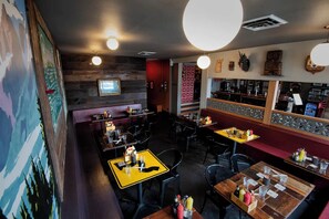 A restaurant with wooden walls, yellow tables, and black chairs. - Cool apartment in vibrant Seattle neighborhood.Restaurants, bars and Light Rail. (Seattle)