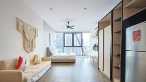 Uma sala de estar moderna com sofá, mesa de jantar e geladeira.