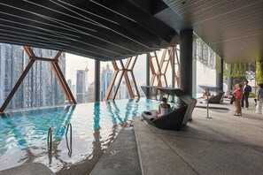 A rooftop infinity pool with a city view, a lounge area with seating, and a bar. - Scarletz KLCC @ Apartments By Edwin 【Located KLCC + 6mins Kuala Lumpur Tower（KL Tower） 】 (Kuala Lumpur)