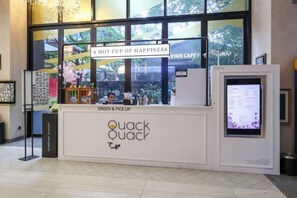 A cafe named Quack Quack with a sign reading 'A HOT CUP OF HAPPINESS' and a digital menu display. - Scarletz KLCC @ Apartments By Edwin 【Located KLCC + 6mins Kuala Lumpur Tower（KL Tower） 】 (Kuala Lumpur)