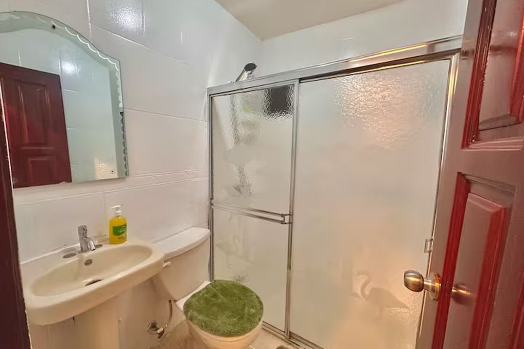 A bathroom with a shower, sink, and toilet.