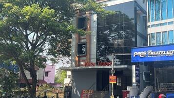 Un edificio con un letrero que dice "Kobe Tower" y un letrero cercano para "The Peps Greatsleepe".