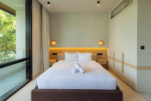 Ein modernes Hotelzimmer mit einem großen Bett, zwei Nachttischen, einem Fenster und Blick auf Grünflächen.