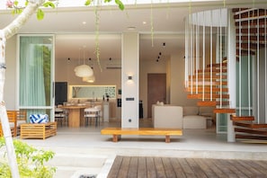 A modern interior with a central seating area, a dining space, and a staircase. - Serenity Ubud by Betterplace (Ubud)