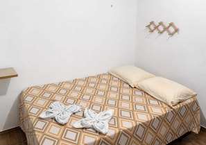 A single bed with a patterned bedspread, two pillows, and two towels on the bed. - Barreirinhas House, near...  Lençois Maranhenses, come with a group of up to 14 people. (Barreirinhas)