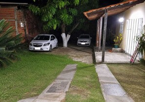 A paved driveway leading to a garage with two cars parked. - Barreirinhas House, near...  Lençois Maranhenses, come with a group of up to 14 people. (Barreirinhas)