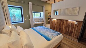Une chambre à coucher avec un lit, une fenêtre, un mur en bois et un miroir.