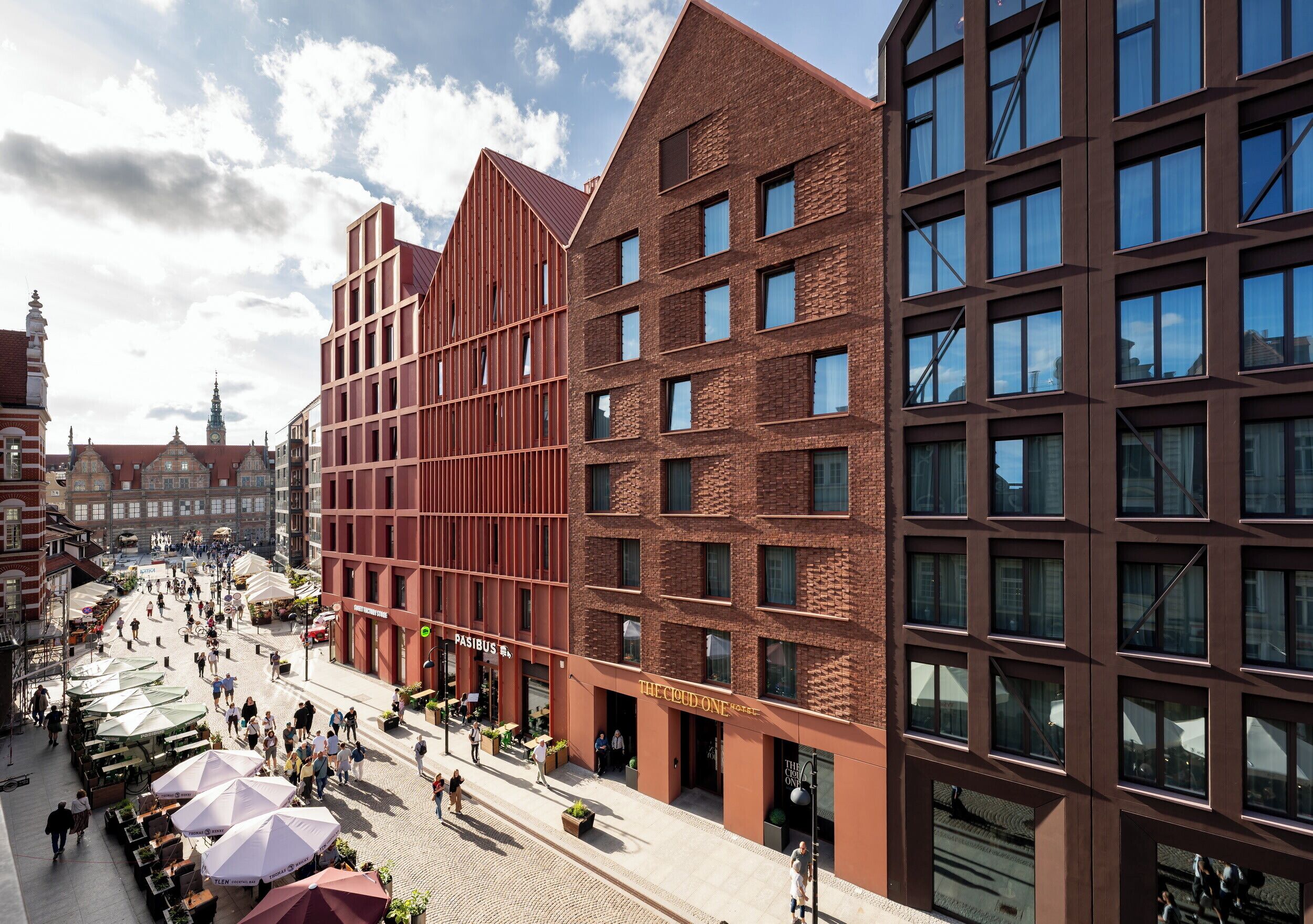 A modern building with a brick facade, large windows, and a flat roof.