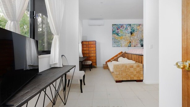 Une chambre à coucher avec un lit, une télévision, un bureau et une commode.