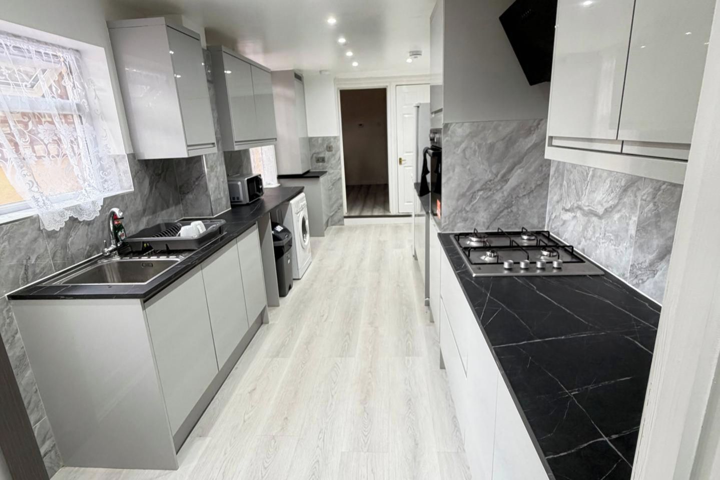 A modern kitchen with a central island, a built-in microwave, and a stove.