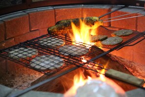 Una griglia con cibo cotto su fuoco vivo.