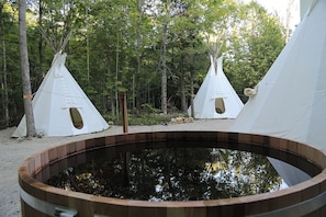A forest with three white tents and a wooden hot tub. - Jeronimo, Tipi for a group of 5 (Markdale)