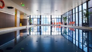 A spacious indoor area with a reflective floor, large windows, and exit signs. - Exclusive Stays - Gallery Penthouse (Southbank)