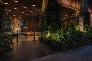 Un edificio moderno con fachada de vidrio, plantas de interior y techo de madera.
