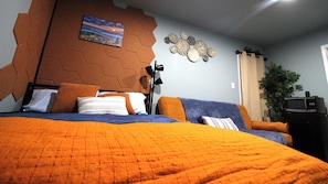 A bedroom with a bed, a sofa, a wall clock, and a plant. - Studio  Walk to AT&T Stadium and Globe Life Field (Arlington)