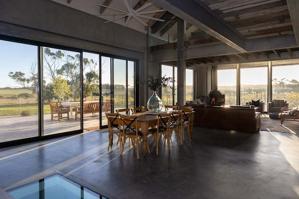 A spacious interior with large windows, a dining area, and a living space.