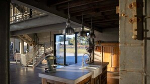 Una cucina con un'isola grande, elettrodomestici in acciaio inossidabile e vista sull'esterno.