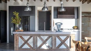 Una cucina moderna con isola centrale, luci a sospensione e vista sul paesaggio esterno.