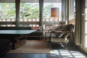 A room with a wooden bench, a sofa, a chair, and a lamp.