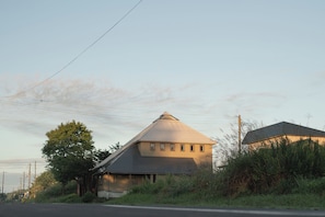 A single-story house with a gabled roof, surrounded by vegetation and utility poles. - ROHAUS: Entire Home with Private Hot Spring (白老町)