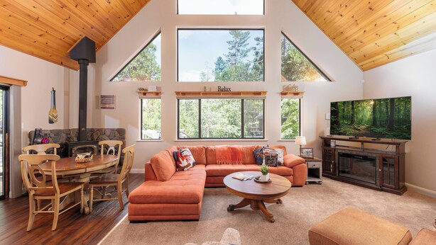 A spacious living room with a fireplace, a large TV, and a cozy seating area. - Cozy Mountain Retreat, 5 Min Walk to  Downtown, Lake Membership, Sleeps 7 (Twain Harte)