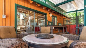 A covered outdoor seating area with wicker furniture and a central fire pit. - Cozy Mountain Retreat, 5 Min Walk to  Downtown, Lake Membership, Sleeps 7 (Twain Harte)