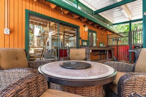 A covered outdoor seating area with wicker furniture and a central fire pit. - Cozy Mountain Retreat, 5 Min Walk to  Downtown, Lake Membership, Sleeps 7 (Twain Harte)