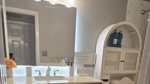 A bathroom with a double sink vanity, a toilet, and a shower area. - Free Parking near Cowboy Stadium (Arlington)