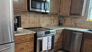 A kitchen with a stainless steel refrigerator, microwave, oven, and dishwasher. - Free Parking near Cowboy Stadium (Arlington)