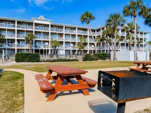 A multi-story hotel with balconies, a barbecue area, and palm trees. - Adorable 1-bedroom condo steps from the beach in Perdido Key - Sleeps 6!! (Pensacola)