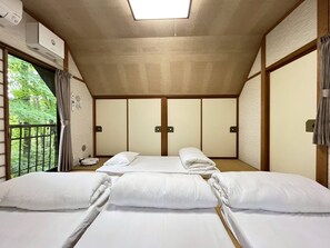 Um quarto com uma cama, uma janela e uma luminária no teto.