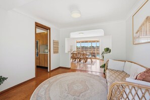 Amplia sala de estar con una mesa de comedor, un sofá y vistas al exterior.