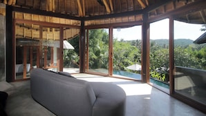Una habitación moderna con un ventanal amplio, un ventilador de techo y vistas al exterior.