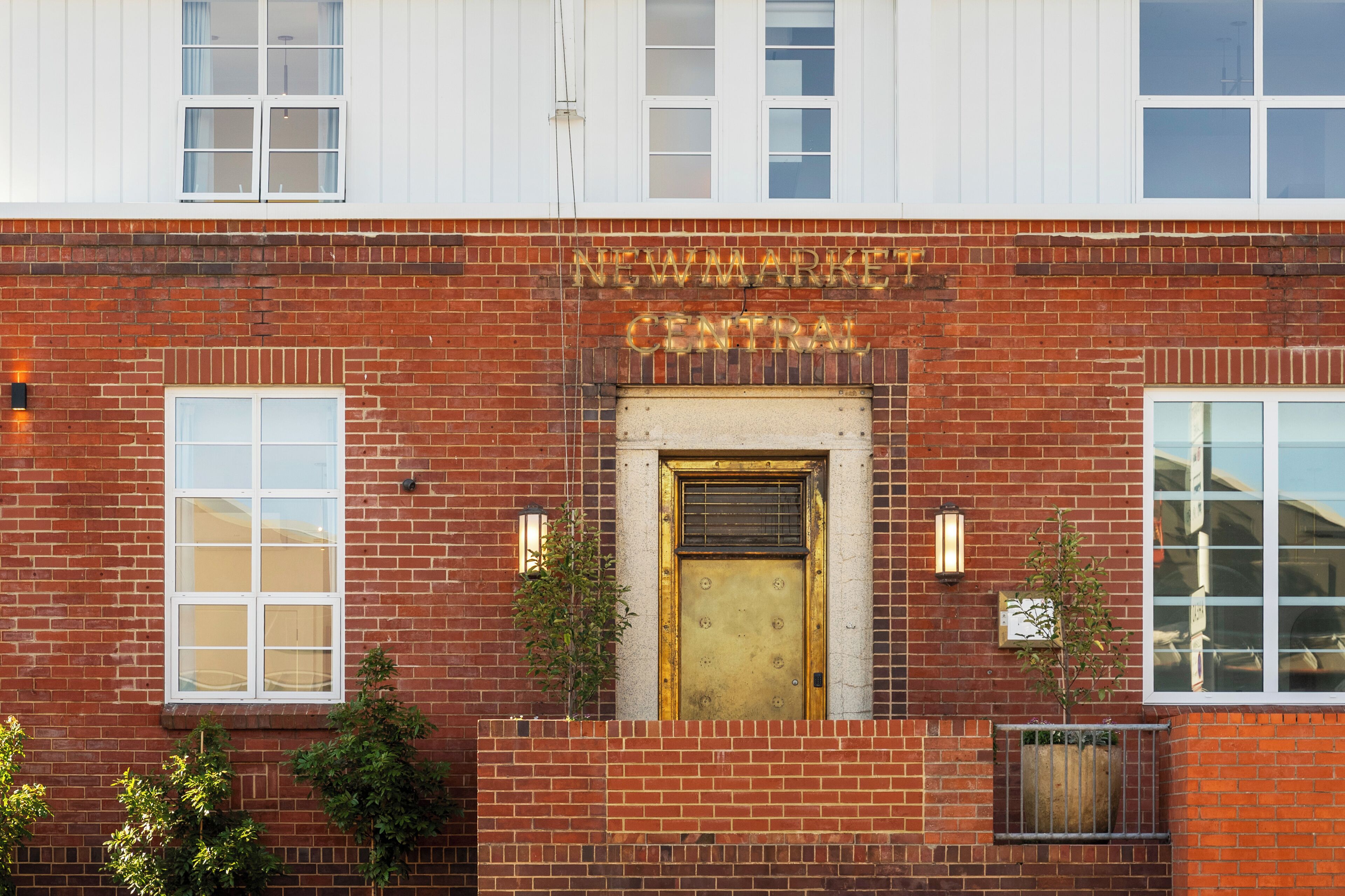 A brick building with a gold door and the words 'NEWMARKET CENTRAL' above it.