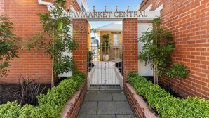 Un edificio de ladrillo con una entrada porticada que indica 'NEWMARKET CENTRAL'.