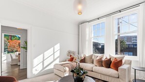 Una sala de estar con sofá, mesa de centro y vistas al exterior.