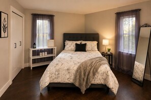 A bedroom with a bed, bedside tables, a mirror, and curtains. - Hidden Sapphire Shores - Near Beach + Fire Pit + Family Retreat (Michigan City)
