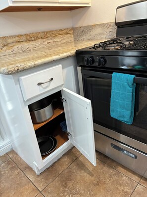A kitchen with a stove, oven, and a drawer with a pot inside. - Soothing studio with AC in welcoming Agoura Hills (Agoura Hills)