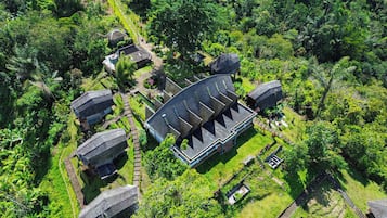 Vista aérea de un complejo de edificios tradicionales rodeado de abundante vegetación.