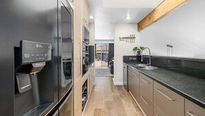 Eine moderne Küche mit Edelstahlgeräten, einem eingebauten Ofen und einer Arbeitsplatte aus Granit.
