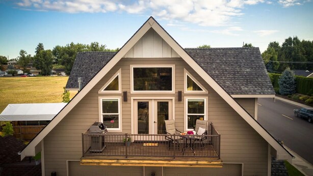 A modern two-story house with a balcony, large windows, and a garage. - Bright Loft Near Wineries & Park | Sleeps 6 (College Place)