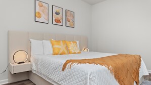 Een slaapkamer met een bed, nachtkastjes en wanddecoratie.