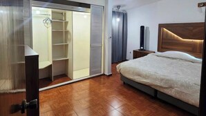 Ein Schlafzimmer mit einem Bett, einem Kleiderschrank und einem Nachttisch.